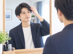 お見合いに向けて、鏡の前で髪を整える男性
