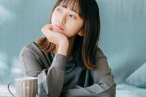 画像：頬杖をついて考えごとをする女性
