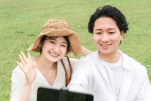 芝生、写真を撮るカップル