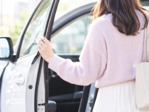 車を降りて、ドアに手をかける女性