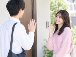 別れ際に笑顔で手を振りあう男女