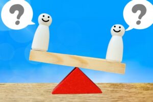 どちらを選ぶか話し合う人々と天秤
