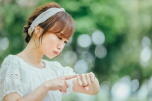 公園で腕時計を見て待つせっかちな女性