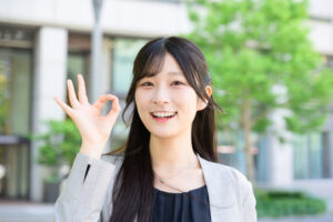 イメージ画像:手でOKマークを作って笑顔でこちらを見る女性