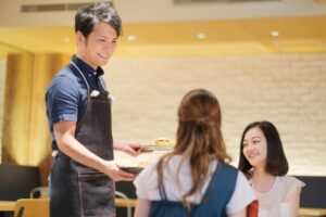 イメージ画像:客席に料理を運ぶ男性店員