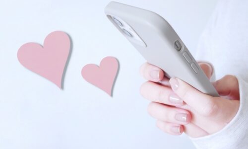 スマホでメッセージを送る女性の手、ハート