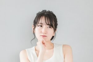 頬杖をついて考える・悩む女性のイメージ画像