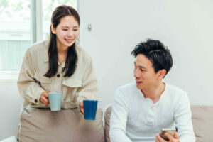 画像:リビングで会話する若い夫婦生活